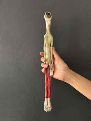 quirky wall sculpture of an antelope wearing red trousers