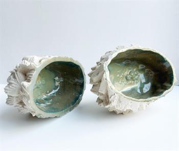 ceramic sculptures in white stoneware with green glaze that look like shells